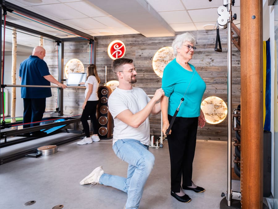 Sporttherapeut begleitet eine Patientin beim Training