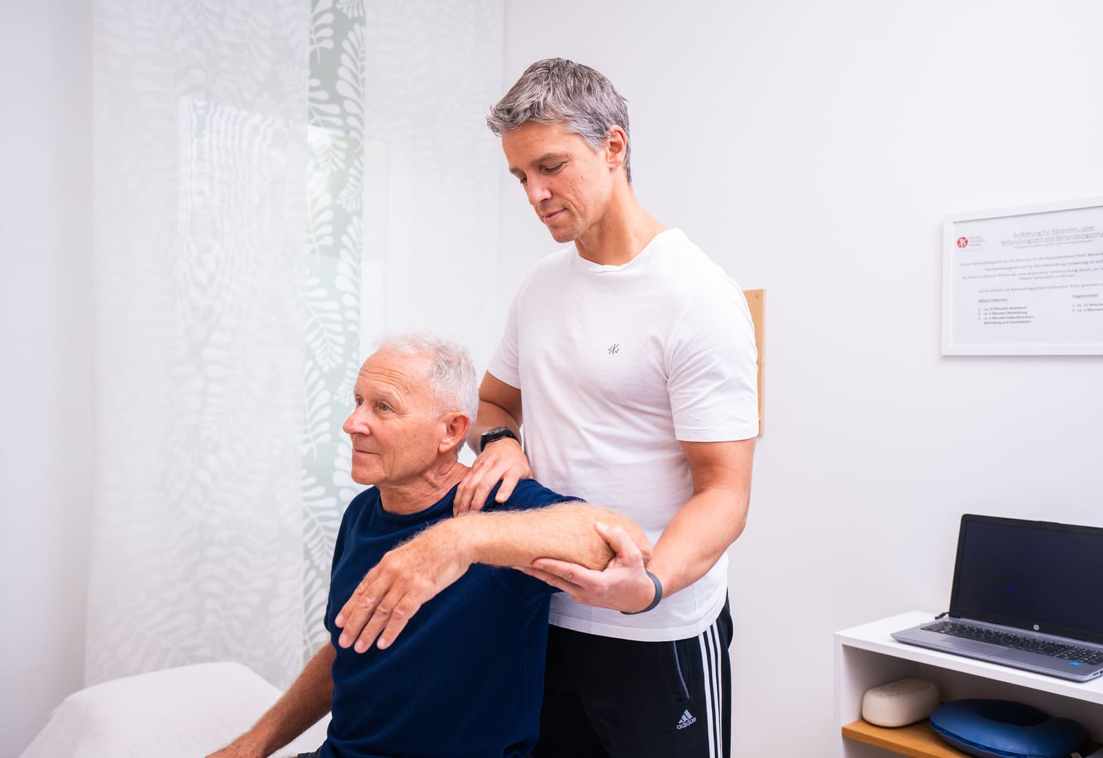 Therapeut behandelt die Schulter eines Patienten