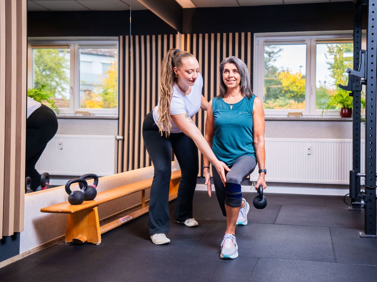 Therapeutin korrigiert eine Übung im Trainingsbereich