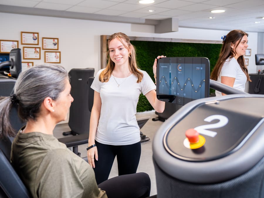 Therapeutin erklärt einer Patientin das EGYM-Gerät